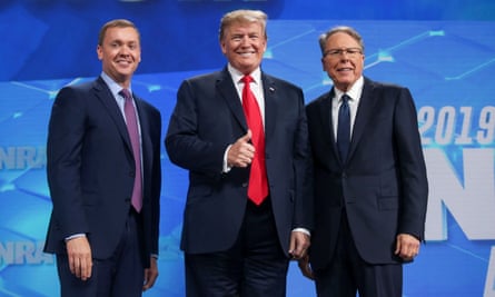 Three white men in a row on a stage smiling.