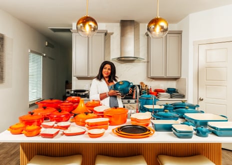 Woman surrounded by orange and blue cookware in a kitchen