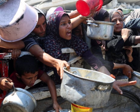 Palestinians wait to receive food from a charity kitchen, amid a hunger crisis, in Gaza City, 23 July 2025.