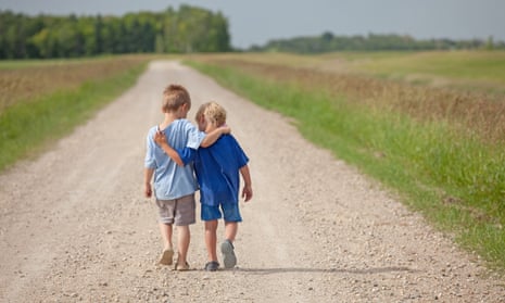Two boys walking down a country road