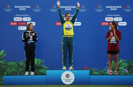Moesha Johnson, centre, on a podium.