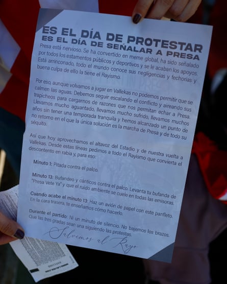 A Rayo Vallecano fan shows the protest flyer against their clubâÂÂs chair