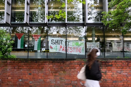 Posters on a building at Goldsmiths next to Palestinian flags read ‘Shut it down 4 Palestine’, ‘Decolonisation is not a metaphor’ and, partly out of frame ‘From the river to the sea’.