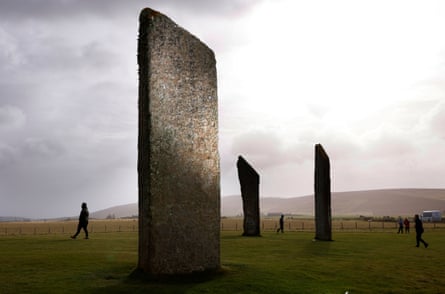 Ring of Brodgar stones with people walking around them