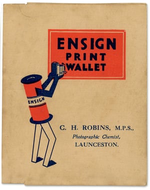 A cartoon-character roll of film with arms and legs takes a photo of a sign reading "Ensign Print Wallet"