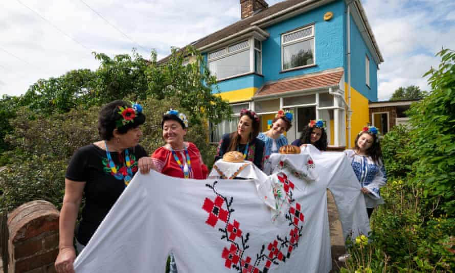 Kristina Korniiuk, 34, (third left) who is originally from Kyiv and fled the Ukraine following the Russian invasion, marks the Ukrainian celebration of Vyshyvanka Day with a giant traditional shirt, in Cambridge.