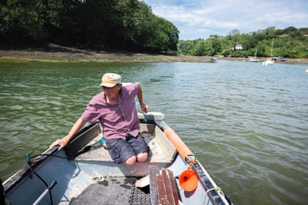 A man steers a small boat through a body of water