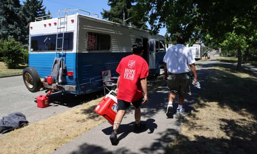 People hand out water to those who might need it and invite them to their nearby cooling center for food and beverages, in Seattle on Sunday.