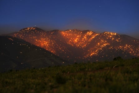 A mountain landscape is aglow with thousands of spot fires.