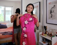 Isabella Lee holds up a hot pink cheongsam embroidered with white flowers