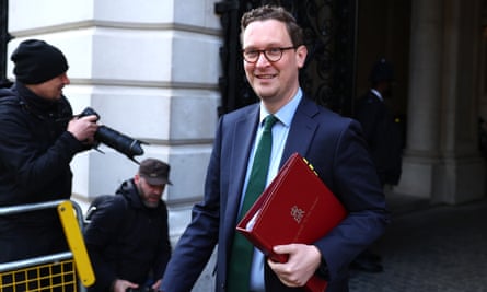 Darren Jones arrives at Downing Street: he wears a suit and tie and holds a red folder under his arm.
