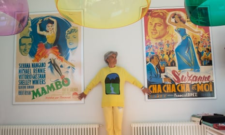 Alejandra Fierro Eleta in yellow standing between two large posters from her collection.