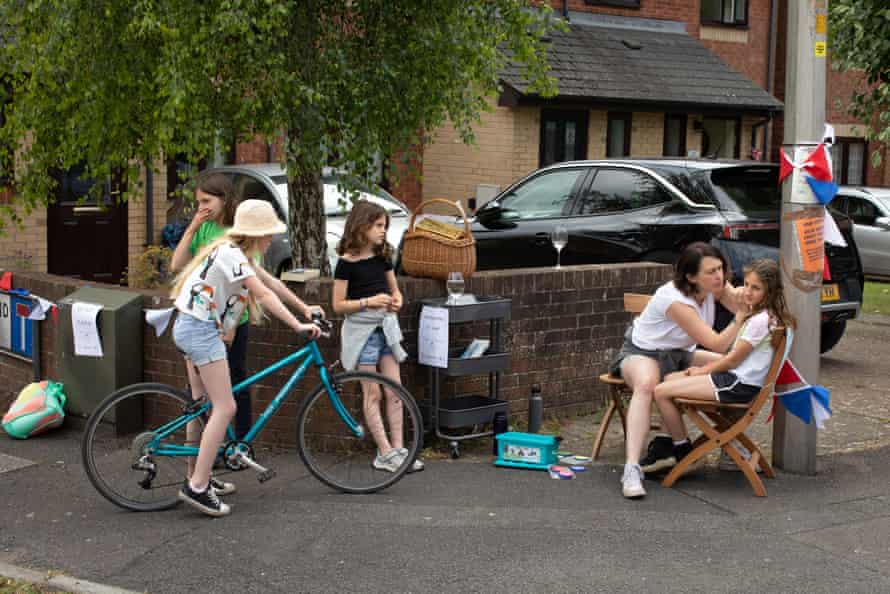 A number of families gather at Woodland Place, Penarth, for a Platinum Jubilee Street party. Here, Lorna Sylvester paints the faces of children attending the Woodland Place street party as other children line up for their turn.