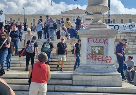 As thousands march in solidarity through Athens anti-Israeli graffiti is daubed at the foot of the Greek parliament.