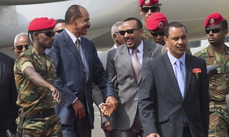 Isaias Afwerki, centre left, and Ethiopia’s prime minister, Abiy Ahmed, centre, greet each other at the airport.