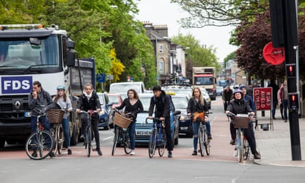 Les cyclistes font la queue aux feux de circulation à Cambridge, devant les voitures et un camion. 
