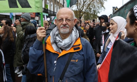 Michael Kalmanvitz stands holding a banner at the protest in Camden