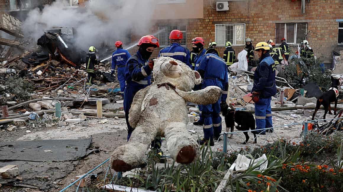 Emergency workers and a giant teddy bear rescued from the rubble