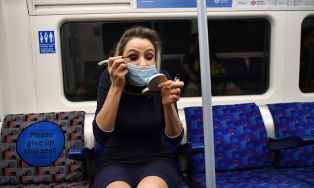 A commuter dons her make-up on an Underground train in central London.