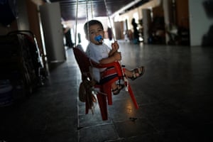 A Syrian refugee boy sits in a swing in an old tobacco factory used as a refugee shelter