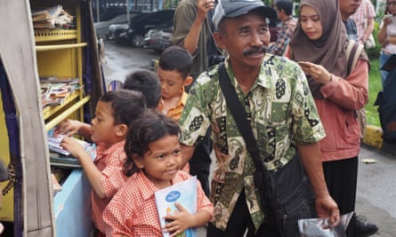 Sutino 'Kinong' Hadi helps children pick out books from his mobile library.