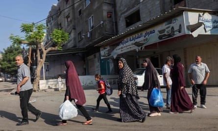 Palestinians carrying their belongings attempt to flee to safer areas in Gaza City after Israeli air strikes and the Israeli military order to evacuate.