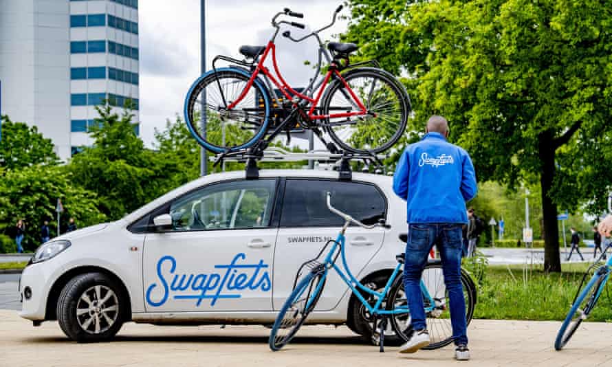 A Swapfiets employee with delivery car in Rotterdam