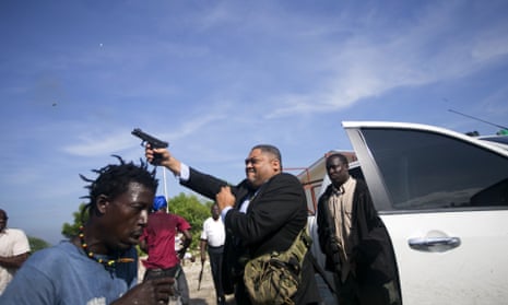 Senator Jean Marie Ralph Féthière, fires his gun outside parliament in Port-au-Prince, Haiti, 23 September 2019. Chery Dieu-Nalio, an Associated Press photographer, was wounded in the shooting.