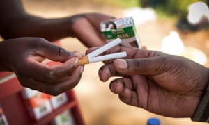 A vendor in Nairobiâs Uhuru Park sells single stick cigarettes.