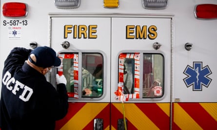 A firefighter seals the windows of an ambulance during the decontamination process after it was exposed to a suspected Covid-19 case in Washington DC.