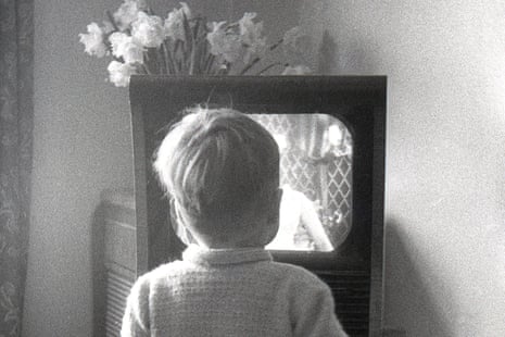 Black and white photo of a boy watching TV