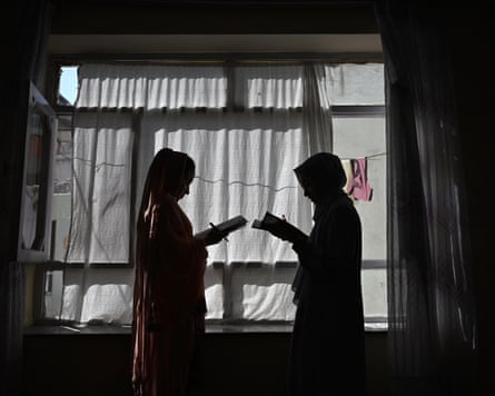 This photograph taken on 6 August 2026 shows Afghan girls attending a lesson by their father at their residence in Kabul.
