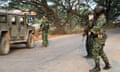 Thai soldiers stand guard as Myanmar villagers flee to Thailand amid clashes between rebels and the junta