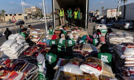 Volunteers load food and supplies onto trucks in an aid convoy for Gaza on 16 October 2023 in North Sinai, Egypt.