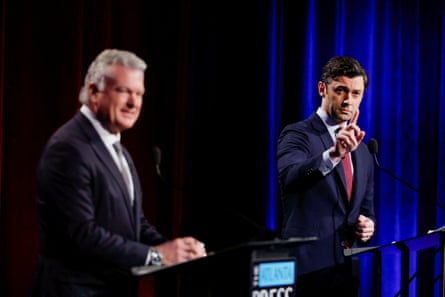 Jon Ossoff raises his hand during a debate