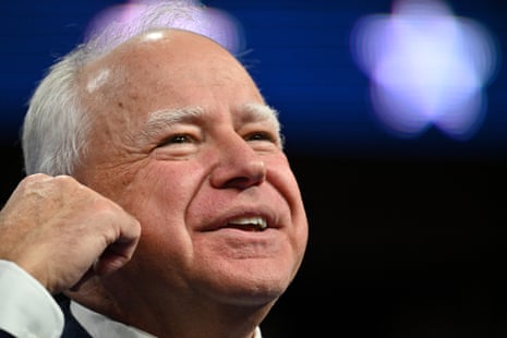 A balding middle-aged man smiles and gestures.