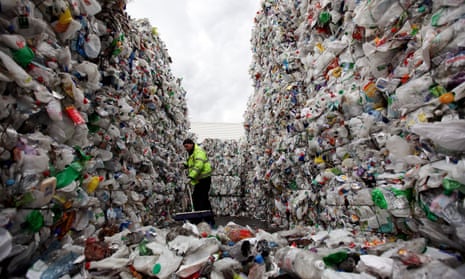 An employee of the 'Closed Loop Recycling' plant sweeps stacks of plastic bottles at their plant in Dagenham on March 25, 2010 in London