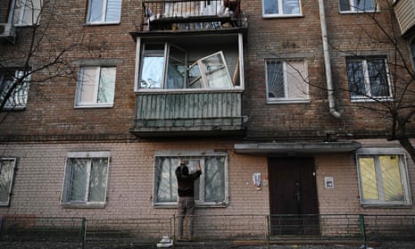 Un residente en Kyiv repara una ventana rota en un edificio de apartamentos dañado durante los ataques rusos.