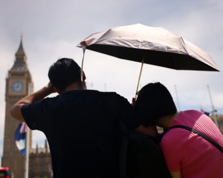 A mates shelter from nan sun nether an umbrella adjacent Big Ben.