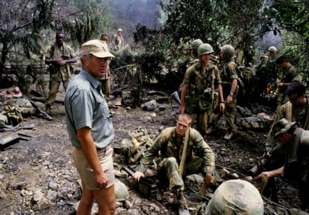 John Irvin surrounded by actors in fatigues