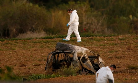Forensic experts walk in a field after a powerful bomb blew up a car, killing investigative journalist Daphne Caruana Galizia in Bidnija, Malta