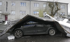 The roof of an apartment building is blown onto a car during a storm in Gelsenkirchen, Germany.