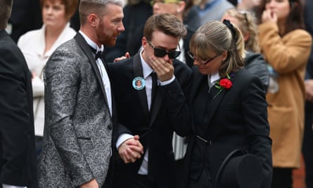 Martyn Hett's partner Russell Hayward in dark glasses, with his hand over his mouth, and being supported either side, at his funeral.