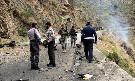 Security personnel inspect the site of the attack near Besham in the Shangla district of Khyber Pakhtunkhwa province.