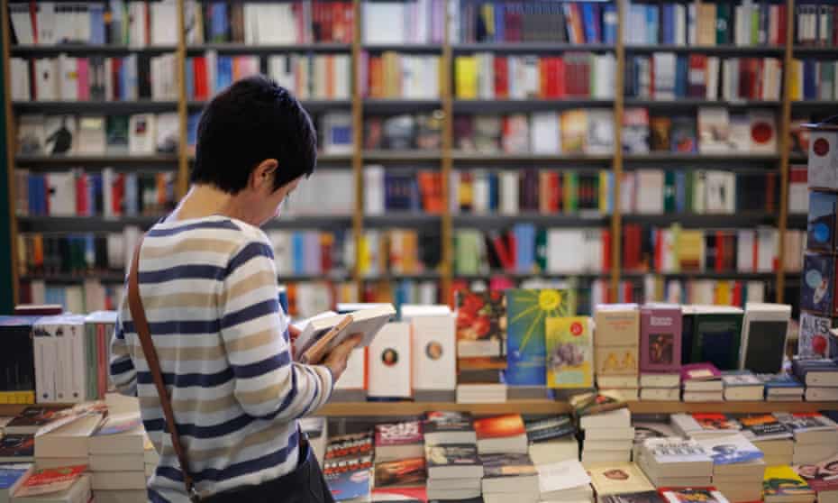woman reading in books in a bookstore<br>BE6RTP woman reading in books in a bookstore