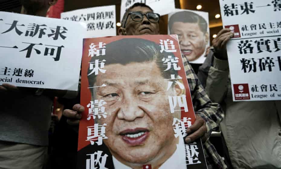 Pro-democracy activists hold up placards of Xi Jinping with slogans including ‘End one party state’ at a ferry terminal in Hong Kong.
