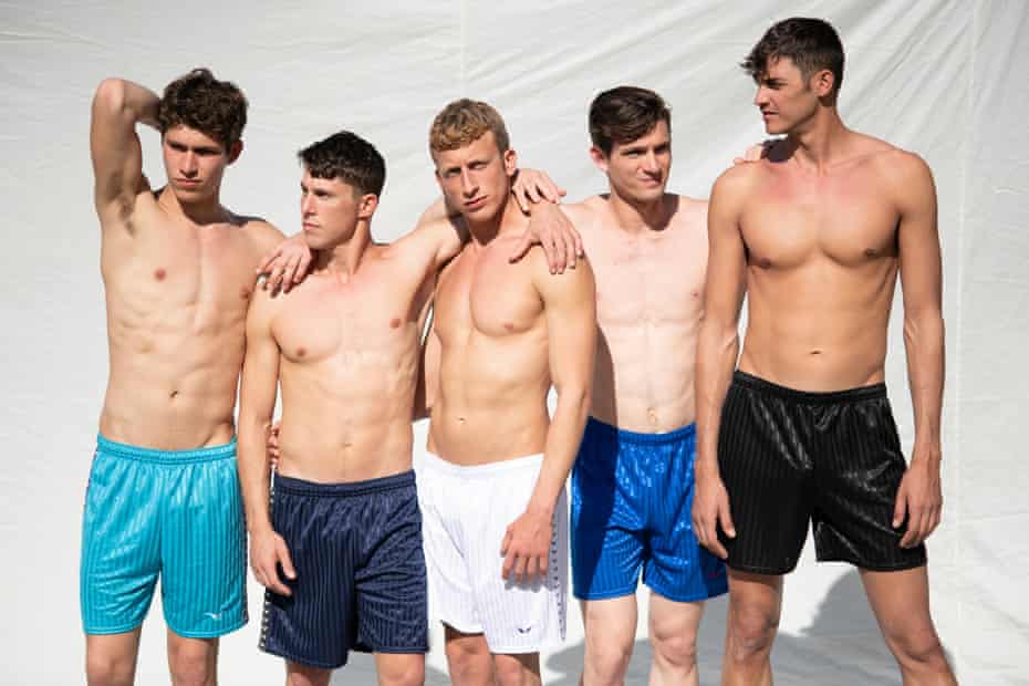 Five young men pose in swimming shorts