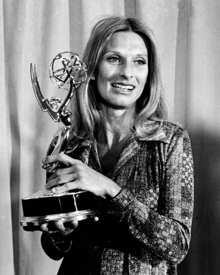 Black and white photograph of Cloris Leachman smiling while looking off camera and holding an Emmy award