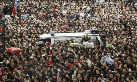 Thousands of passengers pack a main road as they wait to get into the Guangzhou Railway station.