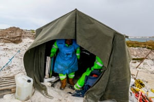 Zimbabweans work on a mined beach in Stanley